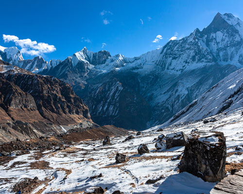 A snow covered valley with mountains in the background.