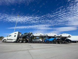 Cross-country car shipping trailer filled with vehicles