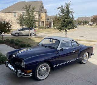 Black classic car parked on a customer's driveway after a snowbird vehicle shipment