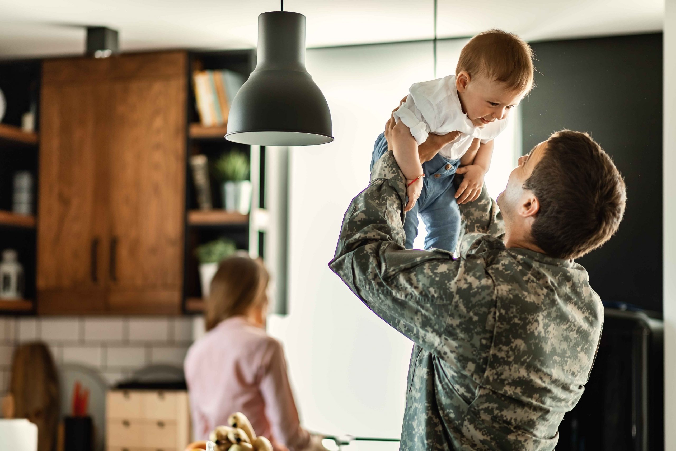 happy-baby-boy-having-fun-with-his-military-dad-home-mother-is-background