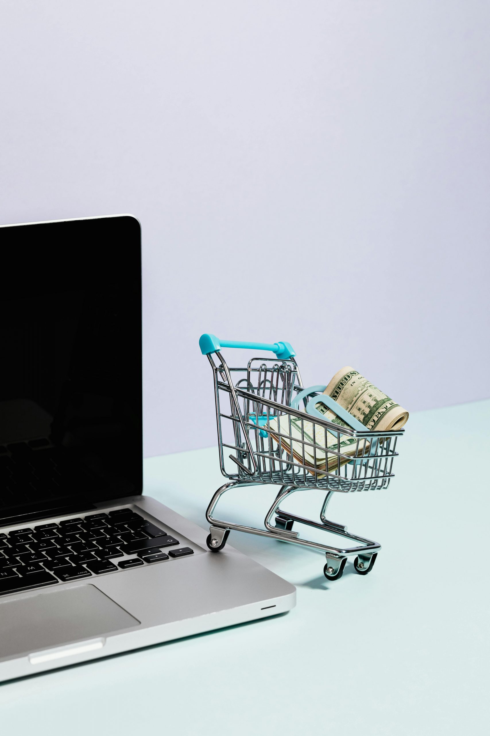 Small shopping cart next to a laptop