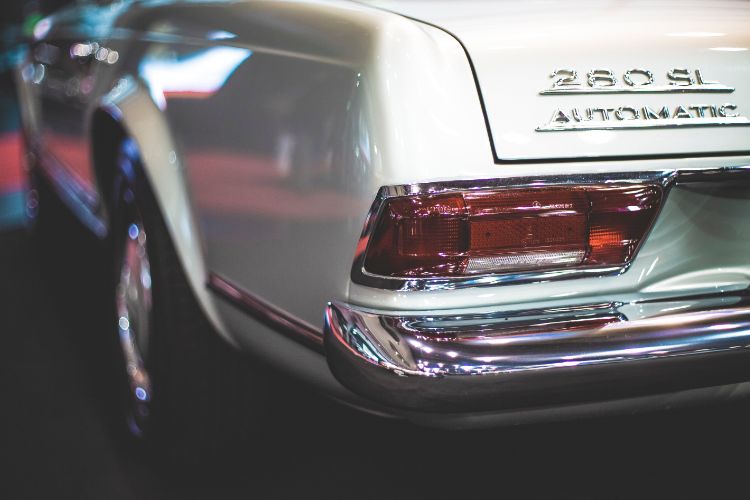 Close-up of the rear end of a classic white Mercedes-Benz 280 SL Pagoda from the 1960s, showcasing vintage luxury car design and chrome details.