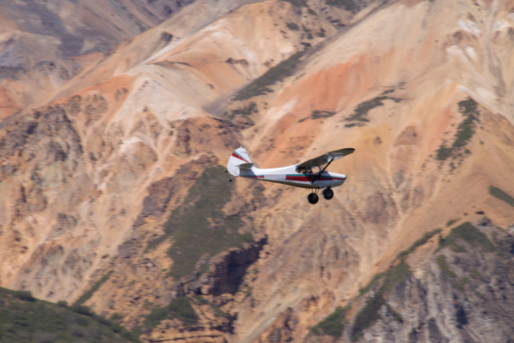 Small bush plane flying over Alaska mountains