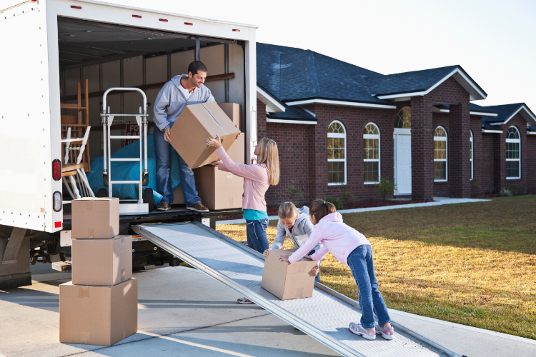 Family unloading boxes during Alaska home relocation