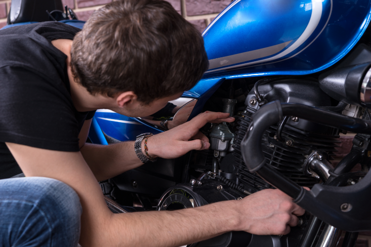 Man inspecting used motorcycle engine closely