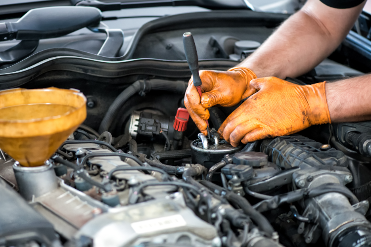 Mechanic draining engine and transmission oil