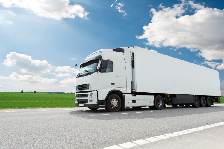 Enclosed truck transporting vehicles cross country