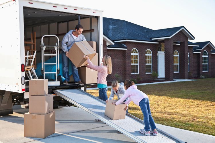Family Moving Boxes Into New House