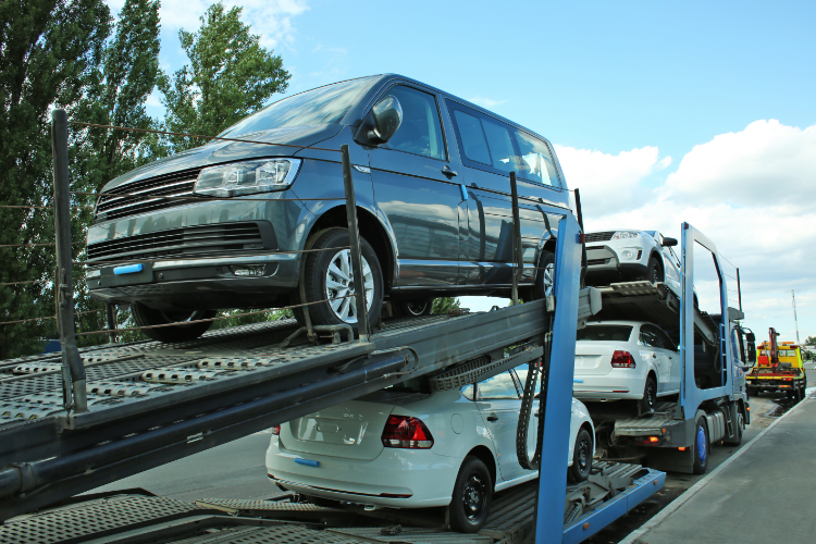Blue van on car carrier truck, roadside