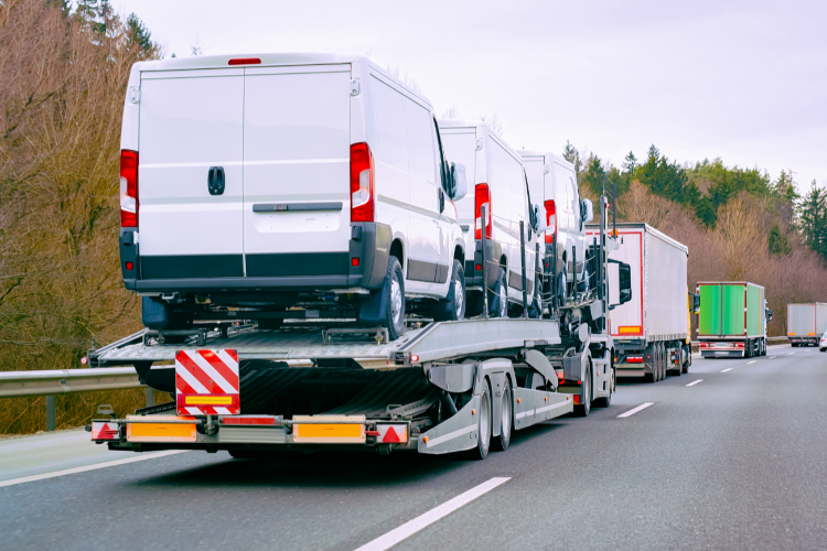 Car carrier truck transporting cargo vans
