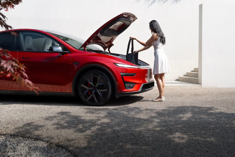 Woman Loading Bag Into Red Tesla