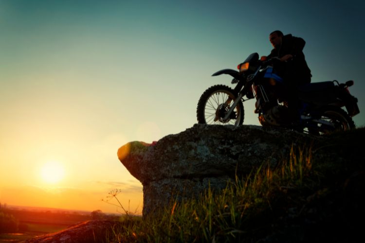 Motorcycle Rider On Cliff At Sunset