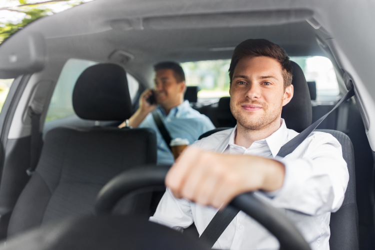Man Driving Car With Passenger Using Phone