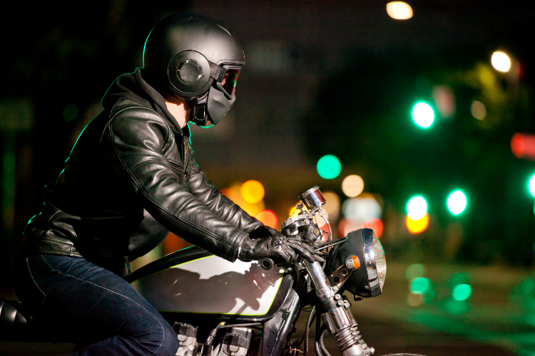 Motorcyclist Wearing Protective Gear Riding At Night