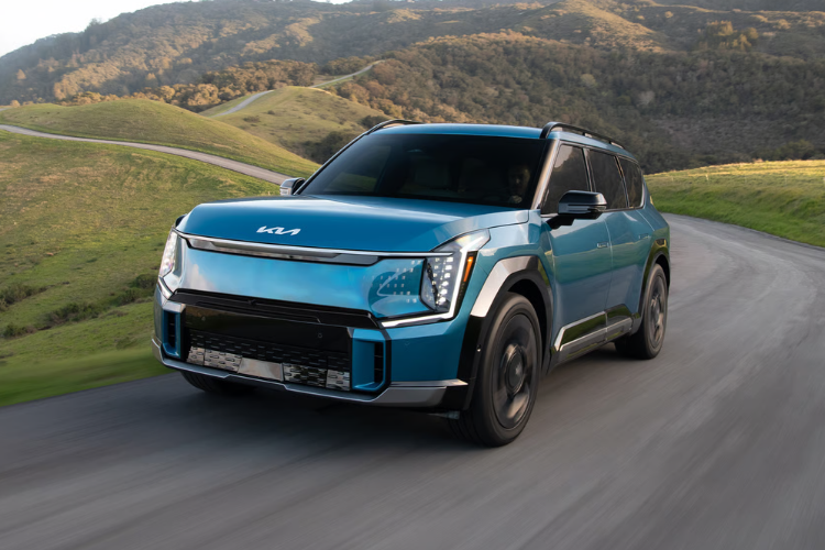 Blue Kia EV9 Driving Countryside Road