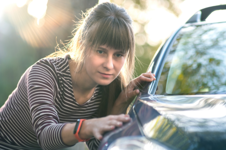 Woman Inspecting Used Car Before Purchase